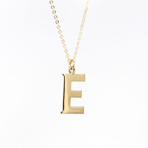 Unique modern circa 2000's era estate 10k yellow gold letter "E" necklace! This lovely charm is the shape of a capital letter "E". The single initial charm is shown modeled on a brand new 14k gold filled 20" chain. A fantastic piece of fine modern jewelry, perfect for anyone with a letter "E" name!  ERA - Circa 2000's - Modern METAL / MATERIAL - 10k yellow gold pendant, 14k gold filled chain MARKINGS / HISTORY - There are no markings, but this piece has been professionally tested.   CONDITION - Good condition. Yellow gold metal has been professionally polished & cleaned. Age appropriate patina & wear remains. Amazing letter "E" necklace!  SIZE / MEASUREMENTS - Chain Modeled: 20 inches, Pendant (including bail): 3/4 x 3/8 inches, Weight (without chain): .61 grams PRESENTATION: Listing inclu Letter E Necklace, E Necklace, 2000s Era, Gold Initial Pendant, Y2k Jewelry, Gold Letter, Initial Pendant Necklace, Letter E, Gold Initial