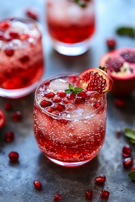 A refreshing pomegranate cocktail garnished with pomegranate seeds and a mint sprig. Pomegranate Syrup Uses, Pomegranate Spritzer, Fresh Pomegranate Juice, Sparkling Water Recipes, Sparkling Water Drinks, Pomegranate Syrup, Ginger Bug, Fizzy Drinks, Party Punch Recipes