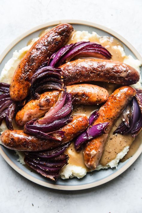 Nothing is quite as belly-warming as hearty British pub food, and our classic bangers and mash recipe is no exception. Bangers And Mash Recipe, Roasted Garlic Mashed Potatoes, The Modern Proper, Modern Proper, Mash Recipe, Bangers And Mash, Plat Simple, Garlic Mashed Potatoes, Garlic Mashed