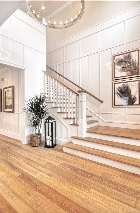 Detailed finish carpentry consists of wainscoting along the walls as well as floor boards and crown molding in this entryway. Vstupná Hala, White Staircase, Diy Staircase, Staircase Remodel, Casa Country, Staircase Decor, Transitional Bedroom, Foyer Decorating, House Stairs