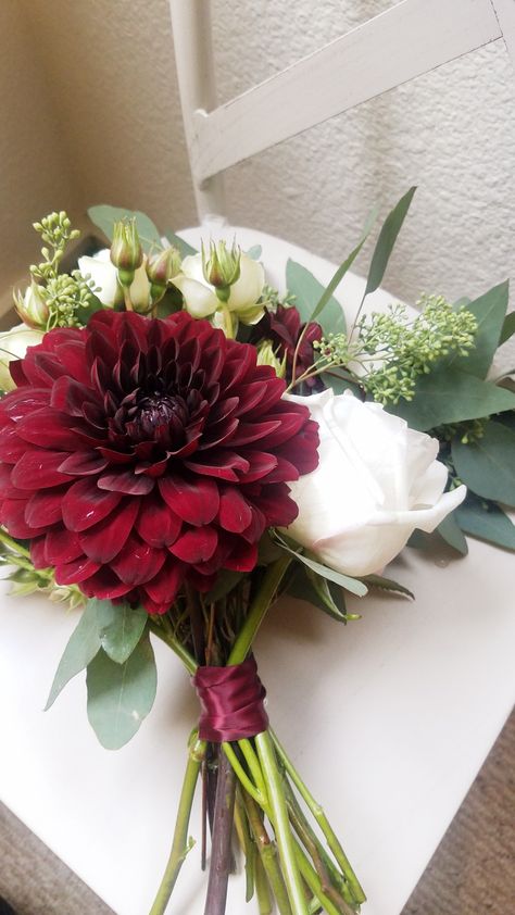 Bridesmaid bouquet with white flowers, eucalyptus and burgundy dahlias. #seededeucalyptus #bridesmaid #bouquet #willowandpinefc #localflorist #flowers Burgundy Flower Bouquet Bridesmaids, Flowers To Go With Burgundy Dress, Burgundy And Sage Bouquet, Burgundy Bridal Flowers, Small Bridesmaid Bouquet Fall, Burgundy Dahlia Bouquet, Red Prom Flowers Bouquet, Burgundy Bouquet Bridesmaid, Red Dahlia Bouquet