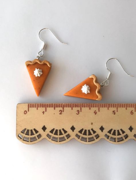 "Celebrate your love of pumpkin spice with these cute miniature pumpkin pie earrings handcrafted from polymer clay. Pie piece measures approximately 17mm wide x 21mm long x 9mm high (1/2\"x 7/8\"x 3/8\"). Because every item is individually hand sculpted, your item may vary from the posted pictures. Every effort is made to insure that items are of equal quality and character.  Available in two different styles. These are a dangle style earring. Also available as a pierce-less, clip on style. Made Pumpkin Pie Polymer Clay Earrings, Polymer Clay Pie, Clay Pie, Pie Earrings, Cute Miniature, Handmade Clay, Miniature Food, Pumpkin Pie, Clay Crafts