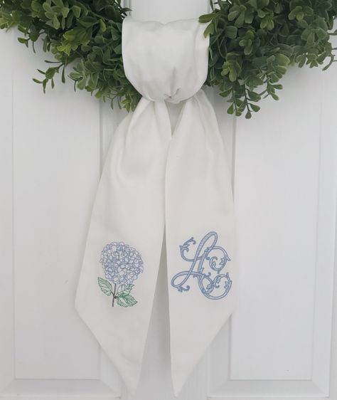 This beautiful hydrangea wreath sash will put the finishing touches on your front porch! It comes with an embroidered hydrangea on one side and a custom monogram on the other. Please message us with a photo of your desired monogram.  Measures approximately 52"x4.5" These are completely sewn by me, which means the embroidery will not be shown through on the other side.  Need a custom one? Send a message and we can help you come up with the perfect wreath sash. Door Wreath Sash, Winter Wreath Sash, Wreath Sash Monogram, Monogrammed Wreath Sashes, Embroidered Hydrangea, Jewish Artwork, Wreath Sash, Fairhope Al, Initial Wreath