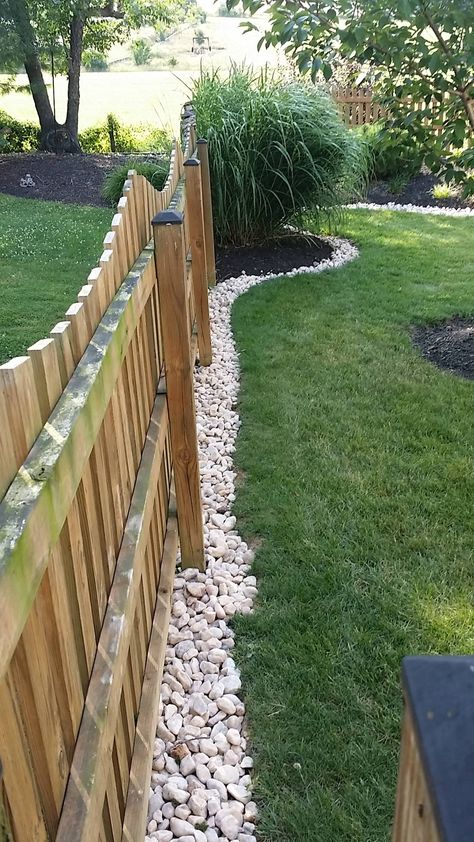 River Rock Along Fence Line, Fenced Front Yard Landscaping, Landscaping Around Walkway Front Yards, Rock Barrier Landscaping, Landscape Ideas Against Fence, Around Fence Landscaping, Outside Air Conditioner Landscaping, River Rock Backyard Landscaping, Under Fence Gap Ideas Backyard