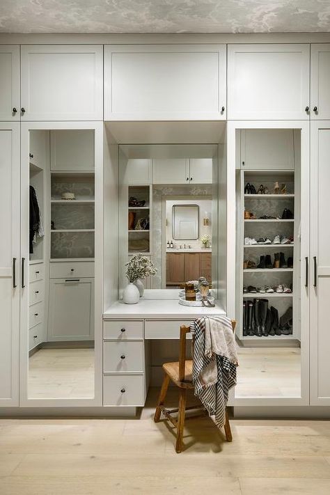 Custom walk in closet with mirrored wardrobe doors features a built in makeup vanity with vintage wooden chair and built in shoe shelves. Built In Vanity Ideas, Closet With Vanity Built In, Lhk Interiors, Built In Makeup Vanity, Closet With Vanity, Closet Turned Office, Marble Herringbone Floor, Shoe Shelf In Closet, Mirrored Wardrobe Doors