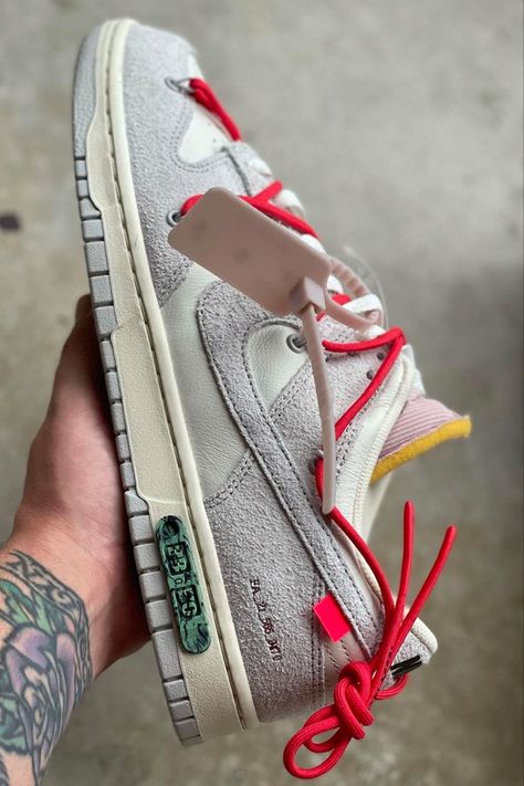 The Off-White™ x Nike Dunk Low Lot 33 is made from a mixture of cream-white leather for the base, hitting up areas such as the perforated toe box, mid-panel underlay, and parts of the heel, and gray suede for the overlaying components, appearing on the toe and vamp, mid-panel to the eyestay placket, Swoosh emblem, rear-quarter, and heel. Additionally, red rope laces weave across the entirety of the upper. Off White Lot Outfit, Off White Dunks Outfit Men, Nike Dunk Low Off White Outfit, Off White Dunks, Hypebeast Shoes, Nike Dunk Low Off White, Dunks Outfit, Off White Sneakers, Off White Nike