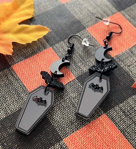 These a earrings are to die for! Featuring acrylic mirror and matte designs. Hang from black plate ear hooks and are nickel free. Measuring roughly 2.75 in Halloween Dangle Earrings, Laser Halloween, Laser Earrings, Silly Earrings, Vampire Coffin, Coffin Halloween, Laser Engraved Earrings, Polymer Clay Jewelry Tutorials, Diy Jewlery