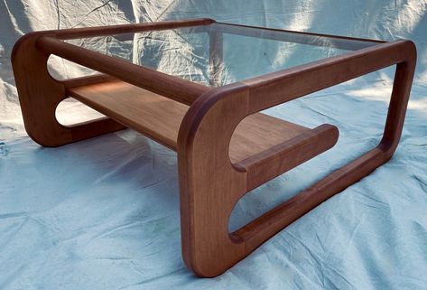 "Made out of locally sourced solid wood, this mid century inspired coffee table will bring a touch of elegance to any room. Constructed with longevity in mind this table will last generations.  Comes in solid Cherry, Maple or Walnut. Walnut is protected with a natural stain to show off the natural beauty of walnut and the cherry/maple can be stained to many options. Example shown is solid maple with a mahogany finish. Measures 36\"x36\"x16\". This item ships via courier and shipping quotes will be available upon request due to the size and shape, prices range from $50 - $200 for domestic shipping and $100 - $350 for international.  Unit comes flat packed and requires assembly." Mid Century Coffee Table Decor, Wavy Coffee Table, Plant Coffee Table, Glass Wood Table, Mcm Coffee Table, Retro Coffee Table, Coffee Table Mid Century, Mid Century Interior Design, 60s Furniture