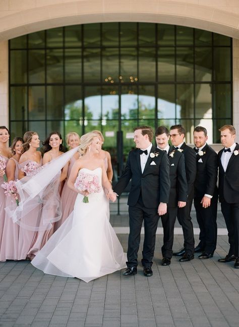 Wedding party photos with the couple before the ceremony. The bridesmaids wore light pink bridesmaids dresses with pink bouquets and black suits for the groomsmen. To see more of this Houston wedding day head to the blog! Light Pink Bridesmaids Grey Groomsmen, Pink Bridesmaid Dresses And Black Suits, Black Suits Pink Dresses Wedding, Black Tie And Pink Wedding, Blush Pink Weddings Bridesmaid Dress, Blush Pink Weddings Groomsmen, Blush Pink And Black Wedding Bridesmaid Dress, Pink Bridesmaids With Groomsmen, Pink Wedding Party Groomsmen