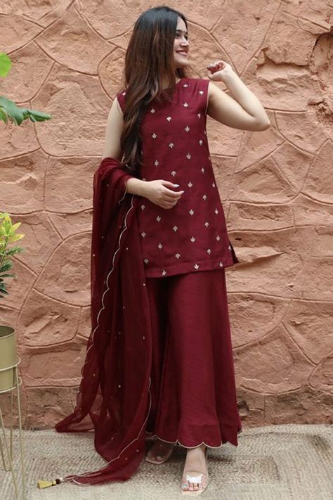 Sway away everyone with your simplicity as you wear this burgundy maroon silk sharara suit which will be scene-stealing ethnic wear to shine in the spotlight.This round neck and sleeveless party wear suit elaborated using thread work.Completed with silk sharara pants in burgundy maroon color with burgundy maroon organza dupatta.Sharara pants is plain.Dupatta designed using stonework.This sharara suit can be customised up to maximum size available in inches 58. Slight color variation may occur du Maroon Suit, Gaun Fashion, Stylish Short Dresses, Pakistani Dresses Casual, Pakistani Fancy Dresses, Pakistani Fashion Party Wear, Beautiful Pakistani Dresses, Salwar Kamiz, Dress Design Patterns