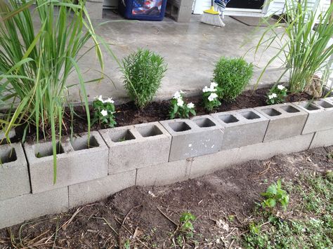 Cinder block flower bed. For less than a dollar a piece, you can create a garden out of cinder blocks. To make it a little more shallow (don't need as much dirt) put cinder blocks along the bottom, as you'll still have 8" planting depth. Block Flower Bed, Cinder Block Garden Wall, Cinder Block Garden Bed, Bed Construction, Sloped Backyard Landscaping, Flower Bed Borders, Tire Garden, Cinder Block Garden, Construction Images