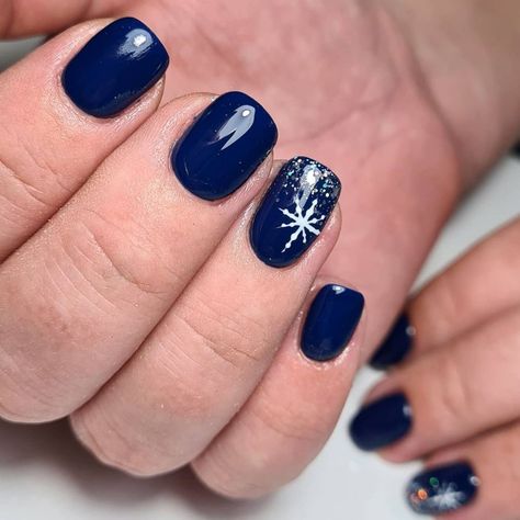 Dark Blue Nails With Accent Nail, Blue Xmas Nails Designs, Navy Xmas Nails, Winter Blue Dip Nails, Navy Snowflake Nails, Dark Blue Nails With Snowflakes, Dark Blue Snowflake Nails, Blue Snowflake Nail Design, Winter Acrylic Nails Ideas