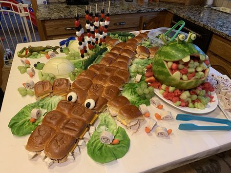 Safari animals food display: crocodile sandwich, hippo melon fruit bowl, pickle frog, pinwheel snails, honeydew turtles, cucumber snake Safari Snake Sandwich, Safari Appetizers Jungle Party, Crocodile Food Ideas, Safari Theme Birthday Food Ideas, Jungle Food Party, Safari Lunch Ideas, Lion Food Ideas, Snake Sandwich Birthday Parties, Safari Theme Charcuterie Board