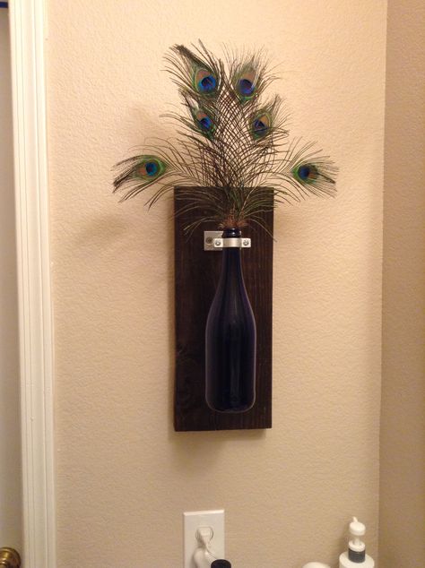 Wine bottle wall decor but because my bathroom is peacock theme I added feathers Peacock Feather Wall Decor, Peacock Feather Wall Art, Peacock Feather Decor Ideas, Peacock Feathers Decorations Home Decor, Peacock Bathroom Ideas, Peacock Bathroom Decor, Peacock Room Decor, Peacock Bathroom, Peacock Feather Decor