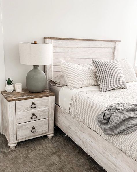 Two-toned rustic wood and white nightstand is perched next to a whitewashed wood shiplap bed in this bedroom. The bed is clad in white and gray striped bedding. Whitewash Bedroom Furniture Decorating Ideas, Guest Bedroom Ideas White Bed Frame, Whitewash Bed Frame, White Headboard Bedroom Ideas Wood, White Washed Bed Frame, Whitewashed Bedroom Furniture, White Washed Headboard, Rustic White Bedroom Furniture, White Wash Furniture Bedroom