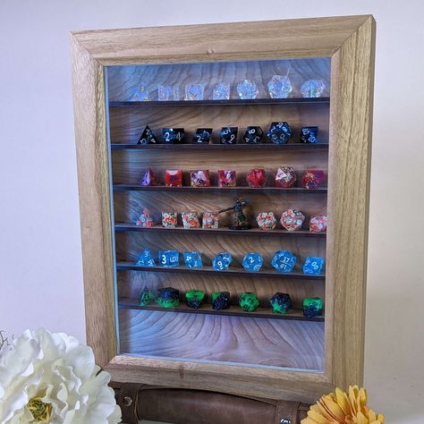 🖐️ Handcrafted wooden Dice and Miniatures Display Case👍 Six shelves for organizing and showcasing dice and D&D miniatures🪟 Front door made of wood and glass for a sophisticated look🔦 Optional lighting feature to enhance the visual appeal🧱 Versatile: can be hung on the wall or stood up on a desk🧐 Perfect blend of functionality and craftsmanship for tabletop gaming enthusiasts. Dice Display Ideas, Dice Display, Dnd Mini, Wood Dice, Lighting Feature, Wooden Dice, Miniature Display, Dragon Dies, Dungeons And Dragons Dice