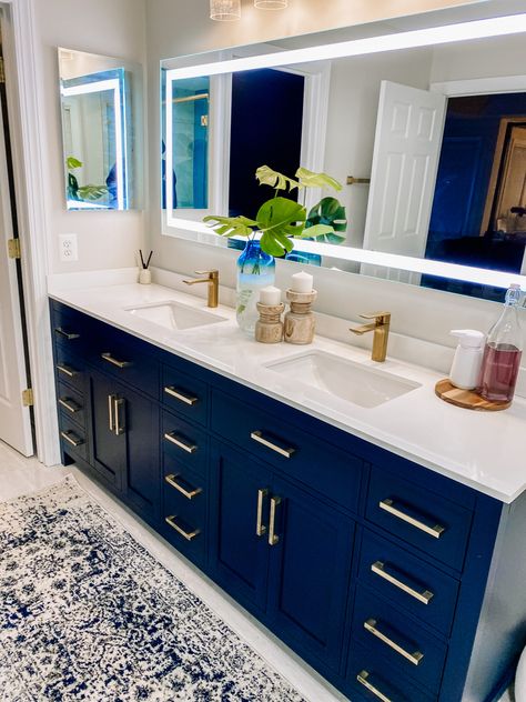 A bathroom vanity that is dark navy blue and has gold accents. This is a master bathroom Navy And Cream Bathroom, Cream Bathroom Decor, Blue Bathroom Accents, Navy Blue Bathroom Decor, House Paint Design, Navy Paint Colors, Navy Bathroom Decor, Master Remodel, Navy Blue Bathrooms