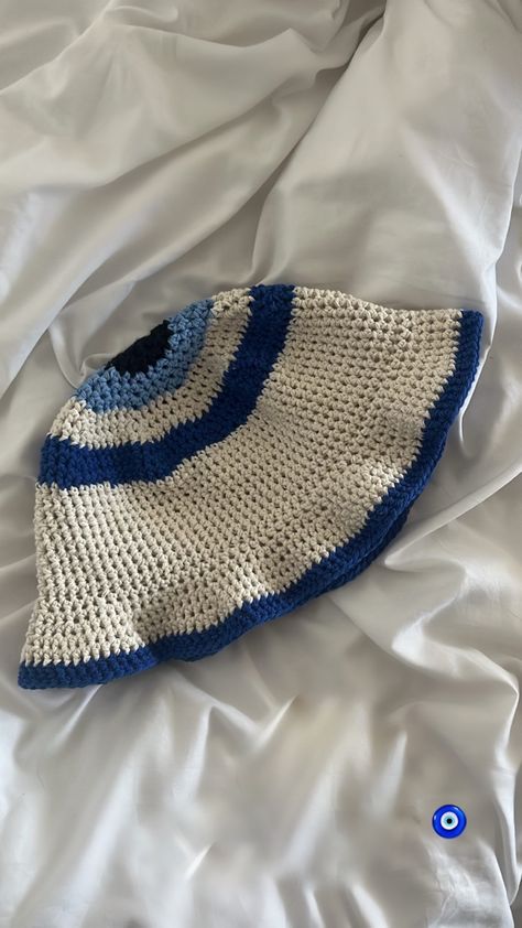 What To Crochet With Blue Yarn, Fun Bucket Hats, Evil Eye Clothes, Crochet Bucket Hat Aesthetic, Crochet Hat Aesthetic, Flower Bucket Hat Crochet, Blue Crochet Ideas, Handmade Blue Crochet Hat, Blue Crochet Bucket Hat For The Beach