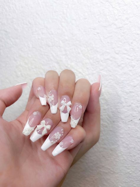 wedding nail inspo: white french tips with pearl flowers & bow charm White French Tip Nails With Charms, Nails With Flower Charms, French Tip Nails With Charms, White Bow Nails, Bow Charm Nails, Nails With Bow Charm, French Tip With Charms, Nail Charm Designs, Nail Charm Ideas