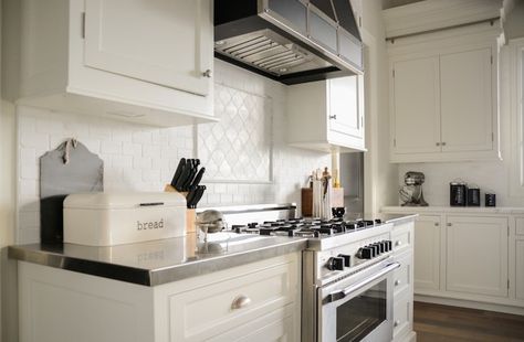 White Arabesque Tiles Amazing kitchen features creamy white shaker cabinets paired with stainless steel countertop and subway tiled backsplash framing black range hood over white arabesque tile cooktop backsplash and stainless steel stove. Stainless Steel Stove Hood, Kitchen Hood Ideas Stainless Steel, Stainless Steel Range Hood Ideas, Stainless Hood Vent Kitchen, White Arabesque Tile, Thermador Range, Thermador Kitchen, Kitchen Hardware Trends, Stainless Steel Hood Vent