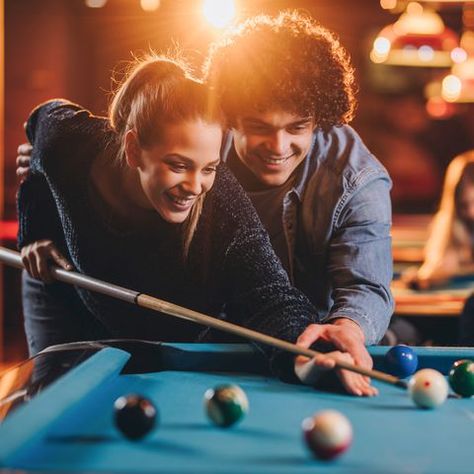 Young happy couple playing billiard in a pool hall. Pool Game Photoshoot, Billiard Couple, Billiard Photoshoot, Billiards Photoshoot, Couple Playing Pool, Game Room And Bar, Billiard Photography, Pool Stick Holder, Playing Pool