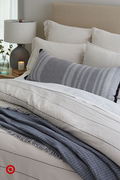 Create your own retreat with a mix of bedding in soft textures and simple patterns. Add pillows and a throw to finish the cozy look. #HearthAndHand Cream And Navy Bedding, White And Navy Bedroom Ideas, Neutral Bedding With Blue Accents, King Size Bed Comforters, King Bedding Ideas, Warm Lighting Bedroom, Blue Bedding Ideas, Chambray Bedding, Lake House Bedding