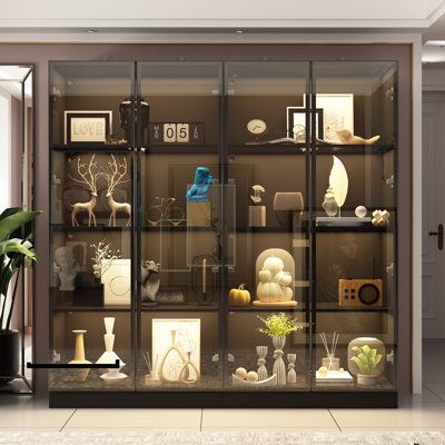 Enhance your space with the 63" Wide 4 Glass Door Display Case, an elegant solution designed to showcase your valuable items with style and sophistication. Crafted for both functionality and aesthetics, this display case features a sleek, modern design that complements any decor, making it a perfect addition to retail stores, museums, galleries, or even your home. Finish: Black | Morinome 63" Wide 4 Glass Door Display Case w / LED Light 63.0 H x 63.0 W x 15.7 D | 15.7" L x 63.0" W x 63.0" H | Wa Lighted Display Cabinet, Home Showcase Design, Glass Display Cabinet Ideas, Luxury Shelves, Transitional Bookcase, Display Cabinet Ideas, Glass Door Cabinet Display, Modern Glass Cabinet, Wall Showcase Design