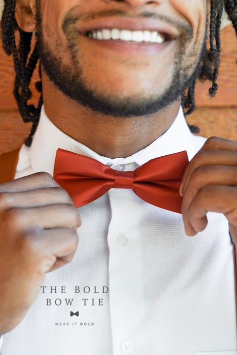 A black man smiles and wears a white shirt. He also wears a shiny sienna bow tie. Burnt Orange Bow Tie, Family Photos Wedding, Wedding Ring Bearer Outfit, Orange Wedding Decorations, Orange Bow Tie, Orange Wedding Themes, Toddler Bow Ties, Yellow Bow Tie, Burnt Orange Weddings