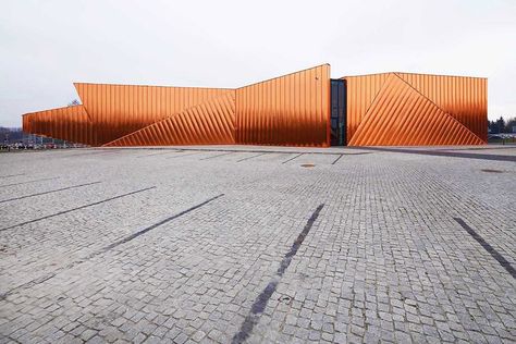 When OVO Grąbczewscy Architekci in Poland was asked to create the city of Żory’s museum, it took a cue from the name Żory, which means fire. Three independent walls are covered with copper plates, designed to look like dancing flames. Covered in a high-resistance varnish, the façade will never patina, keeping its fiery appearance forever. Architecture Cool, Architecture Contemporary, Art Gallery Interior, Metal Cladding, Copper Design, Architectural Visualization, Museum Architecture, Facade Architecture, Exhibition Stand