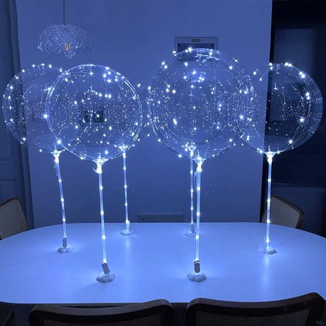 PRICES MAY VARY. [No Helium required] Balloons with sticks can stand up straight around 30-35 inches supported by white base holders that the balloon sticks can fit into. Double-side adhesive stickers are provided to fix the base holders s to a solid surface. [Long LED string lights] for each balloon, light up string lights around 10 foot (300cm) long of a cold white color. The LED string light can tread through the balloon sticks then wrap around the clear balloons and can be easily tied. Cold Wedding Table Decorations Winter, Light Up Balloon Centerpieces, Led Balloon Centerpieces, Starry Night Wedding Centerpieces, Quince Centerpieces, Blue Reception, 21st Ideas, Light Up Balloons, Quinceanera Centerpieces