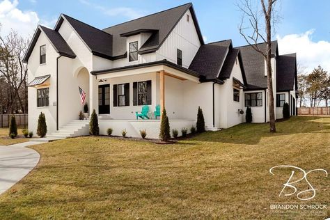 White painted brick and black roof, black windows with black soffit and fascia make this east side Fayetteville custom home stand out! White Brick House With Black Metal Roof, Black Soffit And Fascia White House, Black And White Brick House, Iron Ore Soffit And Fascia, White Soffit Black Fascia, Black Soffit And Fascia, White House’s With Black Shutters, White House Black Windows, Brick Farmhouse Exterior