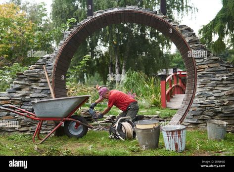 Download this stock image: Perm, Russia - September 01, 2020: worker builds a round entrance called a moon gate in a Chinese-style garden - 2DN60J0 from Alamy's library of millions of high resolution stock photos, illustrations and vectors. How To Build A Moon Gate, Moon Gate Diy, Portal Garden, Round Doorway, Perm Russia, Moon Gates, Moon Arch, Landscape Hardscape, Garden Gate Design