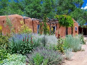 This garden is perfect for the Sante Fe Adobe Home Santa Fe Landscaping Ideas, Canyon Road Santa Fe, New Mexico Landscaping, New Mexico Garden, Southwest Landscaping, Southwestern Homes, Adobe Houses, Adobe Homes, Desert Retreat