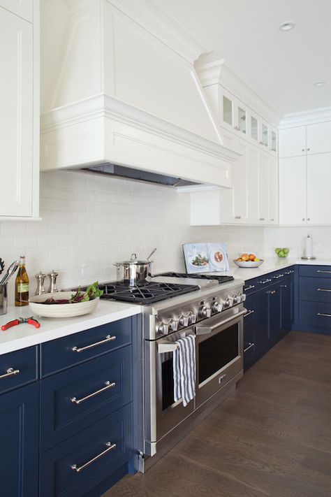 white and navy kitchen with white upper cabinets and navy lower cabinets accented with nickel hardware along with sleek white counters and a traditional subway tiled backsplash framing stainless steel Viking Range under tapered white wood range hood. White Upper Cabinets, Two Tone Kitchen Cabinets, Kabinet Dapur, Blue Kitchen Cabinets, Two Tone Kitchen, Farmhouse Kitchen Cabinets, Popular Kitchens, New Kitchen Cabinets, Blue Cabinets