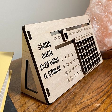 "PLEASE BE AWARE THAT SHIPPING TIMES DURING THIS PANDEMIC MAY BE LONGER. This perpetual wood calendar wood make a great accent piece on your work desk. FEATURES  -You can choose the saying on the calendar or have your own text. -This calendar is approximately 10x5 inches. -It is made with 1/4\" maple plywood. -The stands will not be attached to the calendar to avoid possible breakage during shipping.   HOW TO ORDER 1. Choose if you want the text from the listing calendat or if you want your own Wooden Calendar Ideas, Wooden Desk Calendar, Wooden Perpetual Calendar, Lézervágott Fa, Calendar Wood, Puzzle Wall, Perpetual Birthday Calendar, Wood Calendar, Wooden Calendar