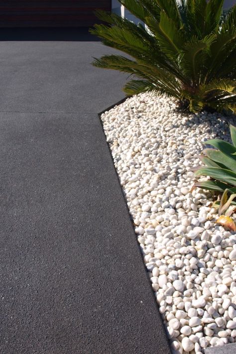 This image shows a concrete driveway coloured Jet Black with a Dulux Avista Colour Hardener. The dramatic tone creates a stunning contrast against the white pebbles in the garden bed. Concrete Driveway Paint, Pebble Driveway, Colored Concrete Patio, Driveway Paint, Cement Driveway, Front Garden Ideas Driveway, Poured Concrete Patio, Garden Pebbles, Concrete Pathway