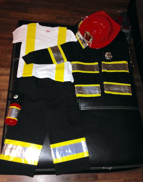 Rock's fireman costume was so simple and inexpensive to make this year! I spent $15 at Walmart on Black cargo pants, a black jacket, yellow duct tape, and silver duct tape. I also spent $5 at Burlington on a fireman tool kit full of accessories. I put yellow duct tape on an old white undershirt to mimic suspenders. This way he will still be in costume even if it is too hot for him to wear the fireman jacket. I ironed everything before I started taping. Fire Fighter Costume Diy, Diy Firetruck Costume, Firetruck Diy Costume, Diy Fireman Costume Kids, Diy Fireman Costumes, Toddler Fireman Costume, Fireman Jacket, Fireman Outfit, Firefighter Halloween