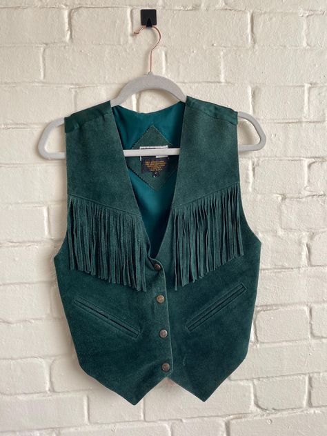 Mona Mode Vintage Mona Mode Western Biker Leather Suede Vest Leather suede waistcoat made in India So hippie, Boho vintage vest in green Fabric is suede leather with 4 snap front closure and with fringed chest.  Back is silky material with tie. Size Small  Measurements  18" armpit to armpit across the front  21" long from shoulder to hem 23" from shoulder to longest point  good preloved vintage condition Western Fringe Vest, Suede Fringe Vest Outfit, Western Vest Outfit, Suede Vest Outfit, Fringed Vest Outfit, Suede Waistcoat, Thrift Inspiration, Vintage Waistcoat, Suede Fringe Vest