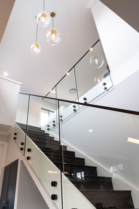 Experience the elegance of matte black sleek stairs with a transparent glass railing. Against a backdrop of pristine white walls, these stairs become the standout feature, blending modern design with a clean and sophisticated aesthetic. Discover the perfect fusion of style and simplicity in this stunning architectural detail. #SleekStairs #MatteBlack #GlassRailing #ModernDesign #CleanAesthetic Montgomery Homes, Glass Railing Stairs, Glass Handrail, Black Window Frames, Black Stairs, Staircase Railing, Staircase Railing Design, Stair Design, Glass Stairs