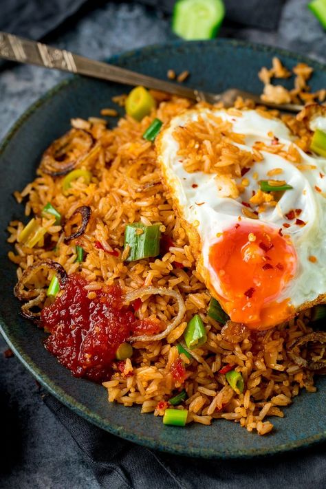 Nasi Goreng is a delicious spicy stir-fried rice. It's more flavourful than regular fried rice with the addition of shrimp paste, fish sauce, tamarind and a few other goodies. Topped with a runny fried egg (those crispy edges are a must!), this classic Asian meal makes a great family dinner. When you're in the mood for street food at home, this is the one to go for. #nasigoreng #Indonesianfood Nasi Goreng Recipe, Tasty Fried Rice, Nasi Goreng Ayam, Chinese Fried Rice, Beef Fried Rice, Healty Dinner, Cibo Asiatico, Spicy Rice, Rice Bowls Recipes