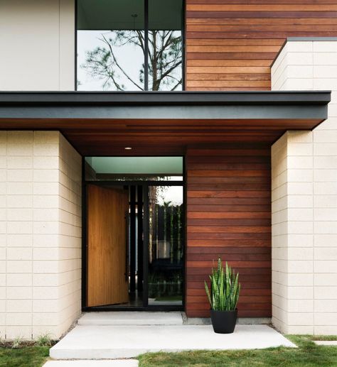 At the McClendon Residence’s entrance, ipe wood siding and soffits contrast with light concrete-block walls. "We used natural materials and colors for a modern aesthetic that would fit in with the neighborhood," explains Andrews. "As you approach, the house is subtle and quiet rather than being ostentatious and loud." #dwell #moderndesign #houston #door Concrete Block Walls, Hardwood Decking, Ipe Wood, Wood Siding, Exterior Wood, Concrete Blocks, Design Within Reach, Braces, Modern Home