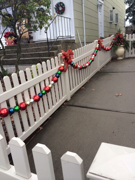 Christmas fence garland Christmas Decor Fence Ideas, Wooden Fence Christmas Decorating Ideas, Privacy Fence Christmas Decorations, Diy Christmas Fence Decorations, Front Fence Christmas Decor, Christmas Decor For Fence, Outdoor Christmas Decorations For Fence, Christmas Fence Ideas, Decorate Fence For Christmas