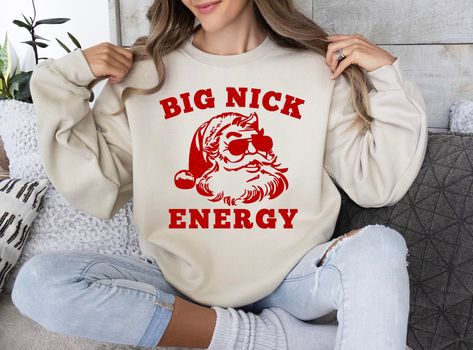 "Big Nick Energy Sweatshirt, Funny Christmas Shirt, Funny Holiday Shirt, Funny Santa Shirt, Christmas Shirt, Very Merry Christmas Party Shirt Step into Big Nick Energy with this sweatshirt, where comfort meets swagger! Made with the softest materials, this sweatshirt wraps you in warmth and lets you relax with Big Nick vibes. It's a snug hug waiting to keep you warm on chilly days. Get ready to rock that relaxed confidence in ultimate comfort, Makes a great gift too! HOW TO ORDER ➀ Select color Funny Santa Shirts, Big Nick Energy, Funny Holiday Shirts, Christmas Party Shirt, Christmas Shirt Funny, Very Merry Christmas Party, Santa Sweatshirt, Christmas Party Shirts, Santa Shirt