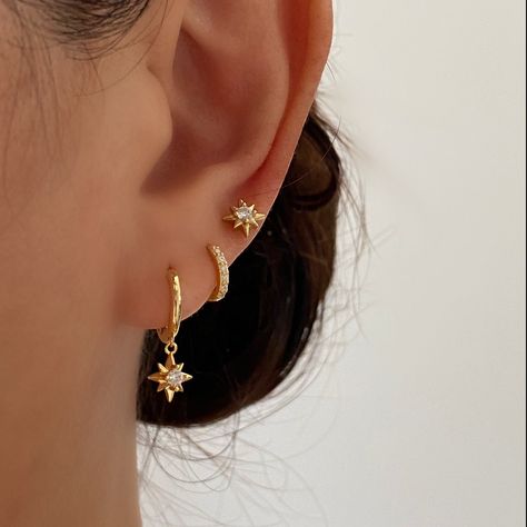 These Gorgeous dainty gold earrings are made of 925 sterling silver with 18k gold plated. They have beautifully crafted north star charms dangling from gold huggie hoop. Perfect for adding sparkle to your daily outfit. Beautifully go with the star stud earrings and basic gold huggies for ear stacking. A. Dangle earrings• Material: 18k Gold Plated on 925 sterling silver• Size: Length : 20mm , Hoop inner diameter: 8.5mm• Safe for sensitive skin• Can wear in the shower• Hypoallergenic, lead and nic Delicate Gold Dangle Earrings, Gold Constellation Piercings, Small Gold Dangle Earrings, Dainty Gold Hoop Earrings, Dainty Dangly Gold Earrings, Dainty Stacked Earrings, Gold Jewelry For Hoco, Cartilage Piercing Ideas Minimalist, Cute Dainty Ear Piercings