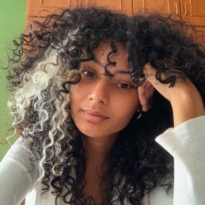 Black And White Curly Hair Aesthetic, White Streaks Curly Hair, Dyed Streaks In Hair Curly, White Skunk Stripe Curly Hair, Black And White Hair Color Ideas, Natural Hair Peekaboo Color, White Highlights On Curly Hair, Silver Stripe Hair, Peak A Boo Curly Hair