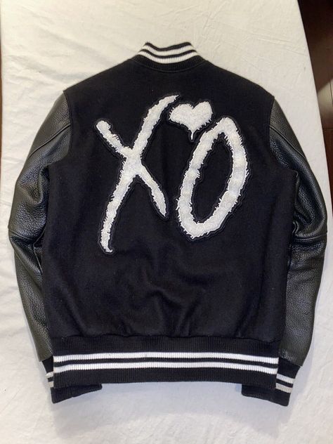 Weeknd XO Varsity Jacket Black and White is inspired by the varsity jacket worn by the singer, song writer and artist Weeknd perfect for COSPLAY. Premium Wool All Climate comfort Ultimate portability, packs like a shirt European Profile - great for layover excursions Liner provides comfort in below 0 climates Features 2 inside pockets decent size to accommodate larger cell phones Action back with pleats for comfort and arm flexibility Windbreaker flap over the main jacket zipper 2 outside cross Xo Jacket, Varsity Jacket Black, Singer Song Writer, Jacket Black And White, Singer Song, Confident Style, Leather Sleeves, Letterman Jacket, Leather Sleeve