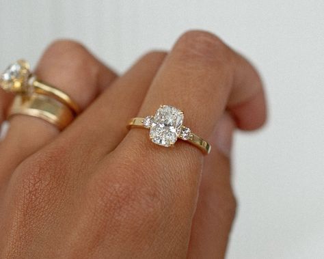 A gorgeous recent custom piece, with a 2.06 elongated cushion cut dimond, 2 round diamond accent stones, set into a low band flat band for a modern feel ✨ Details: - 2.06ct elongated cushion diamond - 2x round diamonds - 18k yellow gold - 2mm wide shank #elongatedcushion #customengagementring #engagementringideas #engagementringdesign #threestoneengagementring #nz #aus Engagement Rings Flat Setting, Cushion Ring Stack, Elongated Cushion Engagement Ring Thick Gold Band, Cushion Cut Elongated Engagement Ring, Bezel Set Elongated Cushion, 3 Stone Elongated Cushion, Elongated Cushion Engagement Ring 2 Ct, Elongated Cushion Engagement Ring Bezel, Elongated Cushion Engagement Ring Thick Band