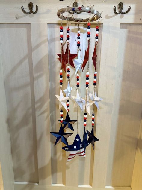 A red, white and blue patriotic wind chime DIY using dollar tree metal stars, a bamboo ring and a 4th of July metal star yard stake. Dollar Tree Red White And Blue Crafts, 4th Of July Plastic Canvas Patterns, Handmade Patriotic Dangle Beaded Earrings, Plastic Canvas Memorial Day, Star Wreath Form, Patriotic Beaded Dangle Earrings, Dollar Tree Patriotic Crafts, Patriotic Candles, Red And White Flag