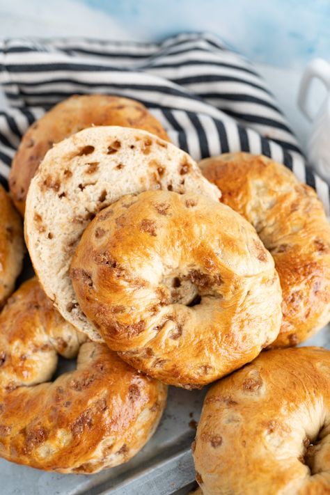 A pile of maple bagels - one is sliced in half. Brioche Bagels, Panera Cherry Vanilla Bagel, Different Bagel Flavors, Maple French Toast Bagel Recipe, French Toast Bagels, Sourdough Cinnamon Bagels, Sourdough Bagel Flavors, Savory Bagel Recipe, Homemade Cinnamon Swirl Bagels