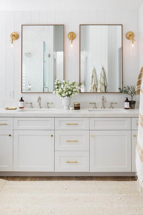 Cottage style bathroom features a cream jute runner in front of a white dual shaker washstand with brass pulls topped in white honed marble with nickel hook spout faucets and light brown oak mirrors flanked by glass and brass sconces mounted on a vertical shiplap wall. Mixing Metals In Bathroom, Coastal Bathroom Design, Pure Salt Interiors, Beautiful Bathroom Decor, Guest Bathroom Remodel, Beautiful Bathroom Designs, Timeless Bathroom, Bathroom Design Trends, Chrome Bathroom